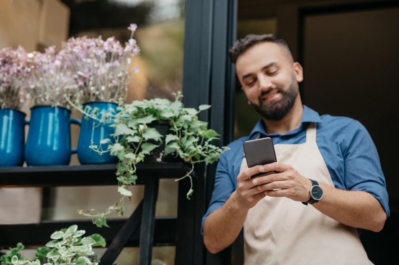 Florist checking his phone in his flower shop