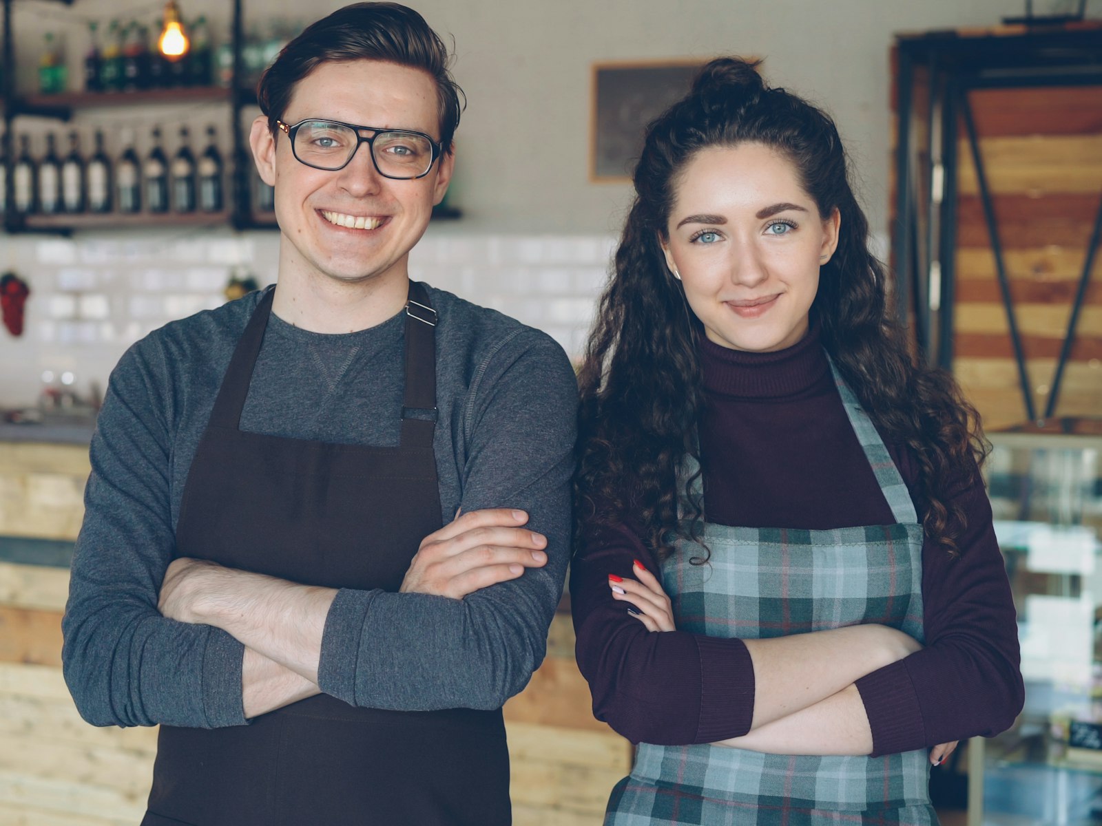 Two cafe owners standing confidently in their shop