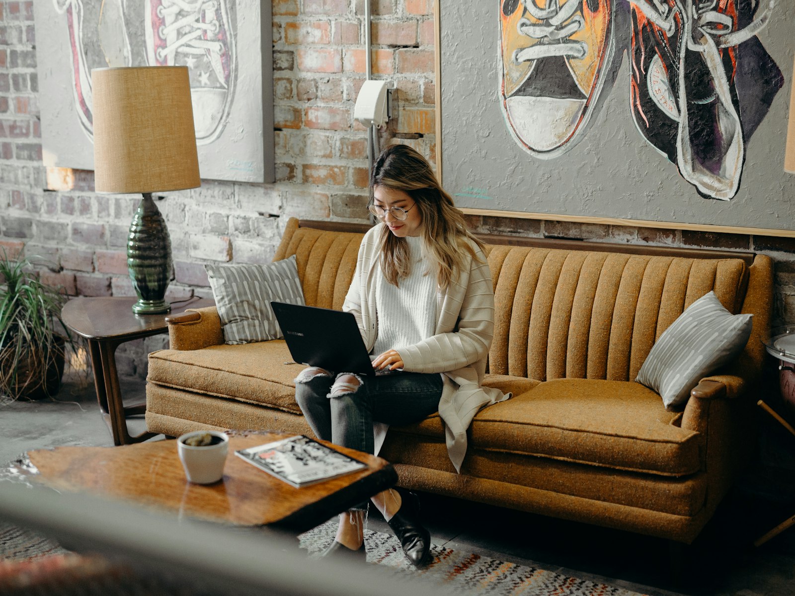 Woman on a sofa reviewing loan options on a laptop