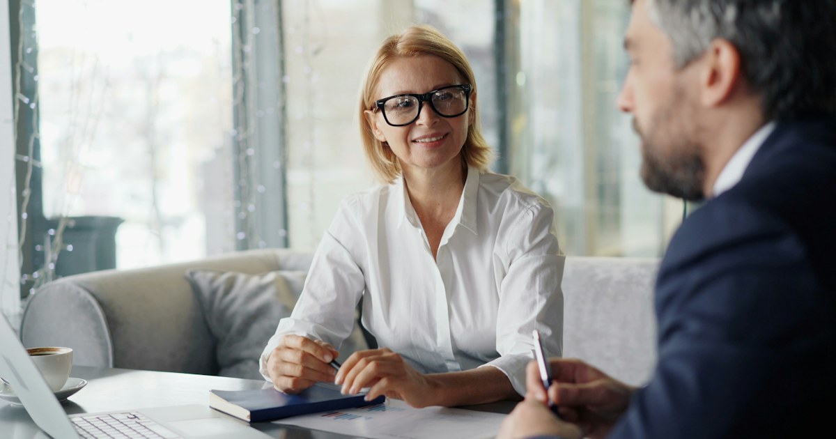 A business funding advisor meeting with a client at a café table